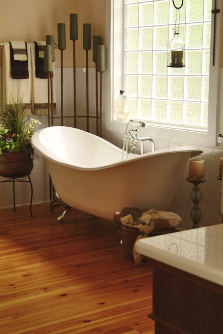 Bathroom renovation by fis finishes A stylish freestanding bathtub in a bright, warmly lit bathroom setting.